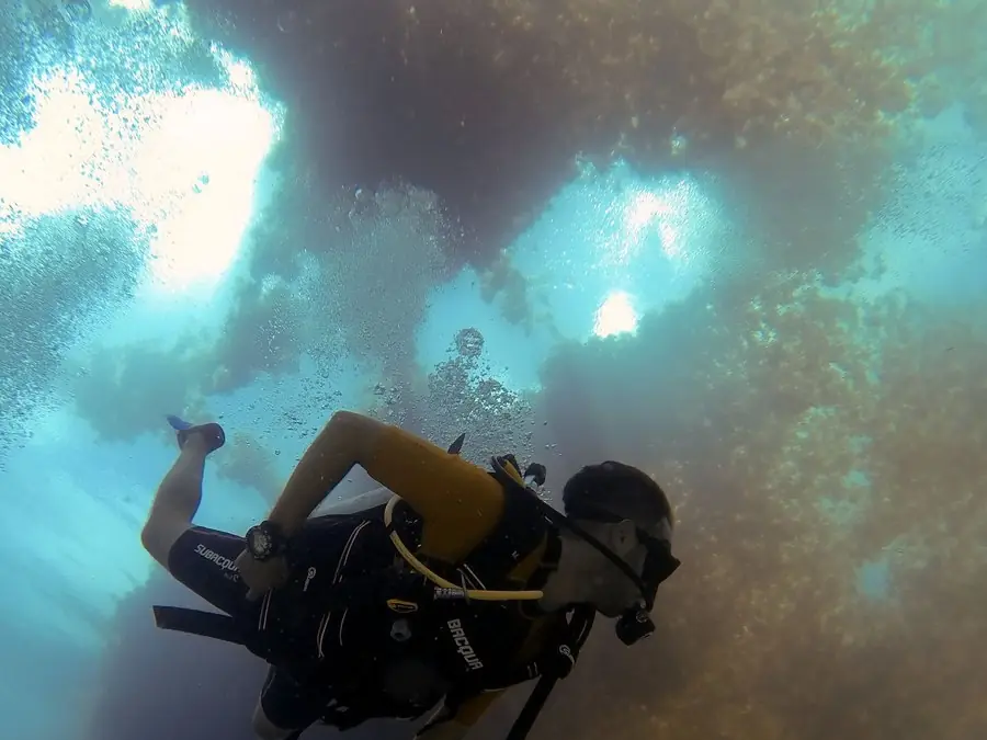 Un buzo desciende en el azul, con burbujas